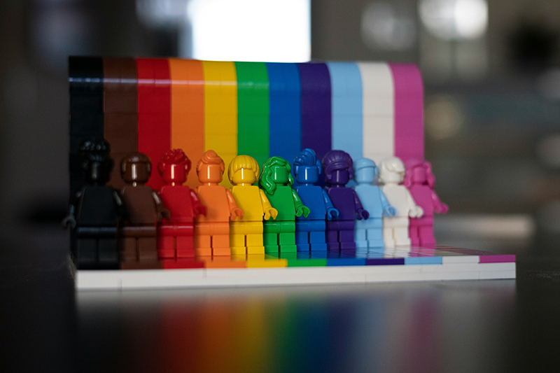 colorful lego figurines lined up to form a rainbow